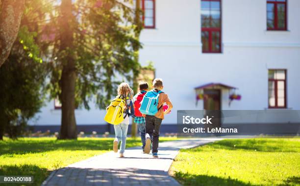 Children With Rucksacks Running In The Park Near School Stock Photo - Download Image Now