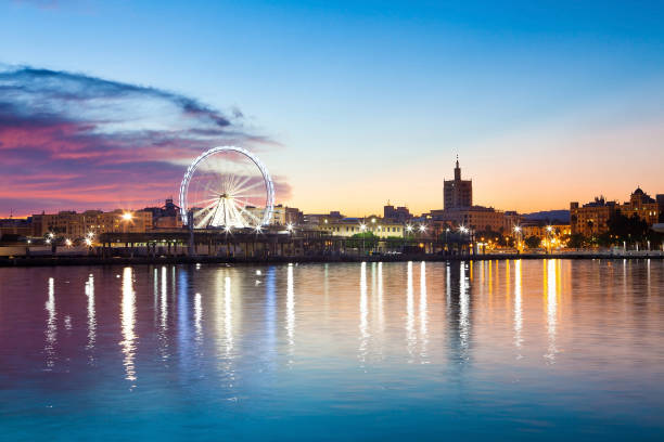 istock Sunset cityscape with ferris wheel in motion. Malaga city, Spain. 802420636