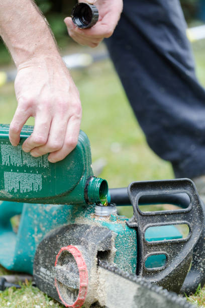 istock Handyman replenishes the oil in chain saw 802421480