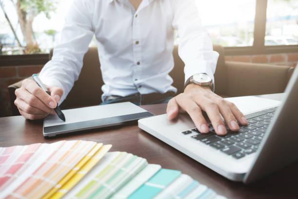 istock Graphic design and color swatches and pens on a desk. Architectural drawing with work tools and accessories. 802425160