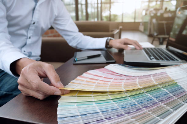 istock Graphic design and color swatches and pens on a desk. Architectural drawing with work tools and accessories. 802425190