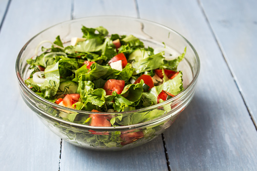 a bowl of fresh salad with tomatoes and cheese onion