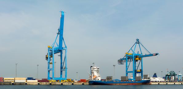 Ship in the Zeebrugge cargo container terminal harbor on sunny day