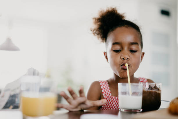 istock Girl with twisted hair is drinking milk through a straw 802443696