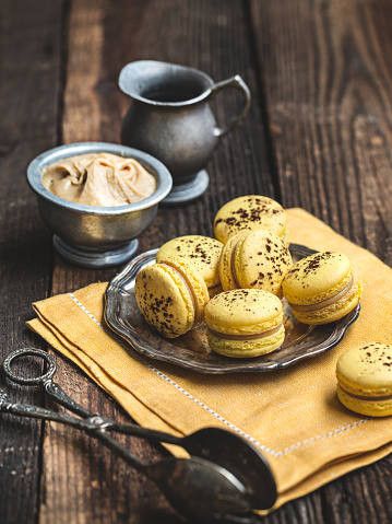 Banana macarons on a rustic wooden table.