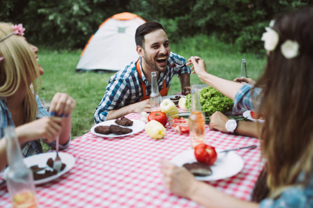 istock Cheerful friends sitting at table and having meal 802449592