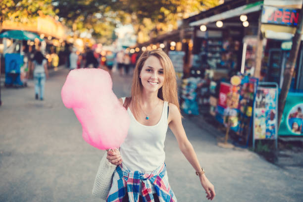 istock Happy woman holding pink cotton candy 802451890