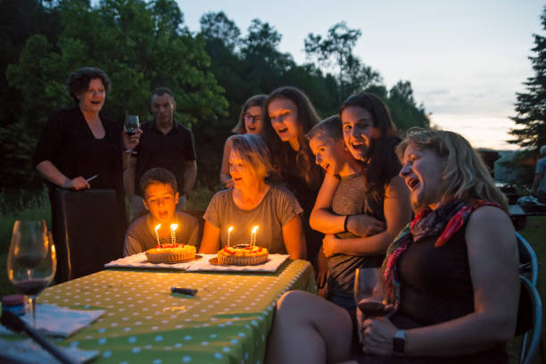 istock Big dinner: grandmother celebrating birthday outdoors at dusk. 802458812
