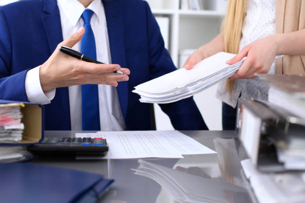 istock Bookkeeper or financial inspector and secretary making report, calculating or checking balance. Internal Revenue Service inspector checking financial document. Audit concept. 802458896