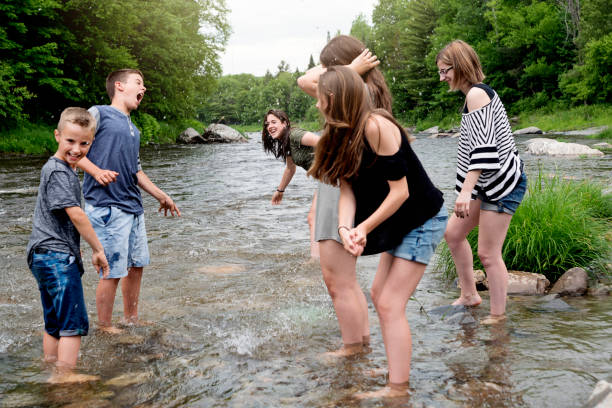 istock Kids playing in river in summer nature. 802459710
