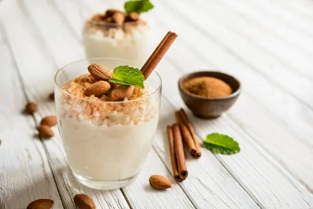 Creamy rice pudding topped with cinnamon and almond served in a glass jar