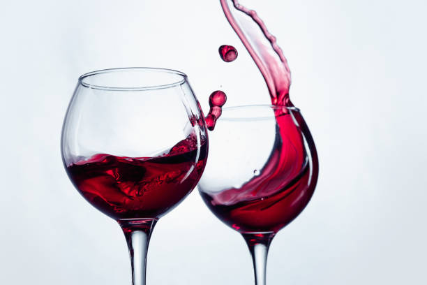 istock Two wine glasses in toasting gesture with big splashing 802472426