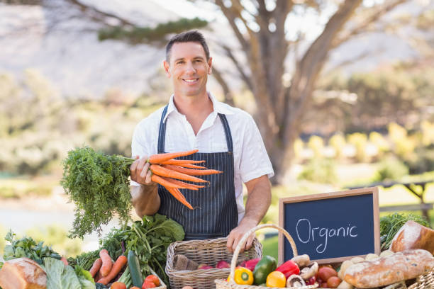 istock Smiling farmer holding a bunch of carrots 802472466