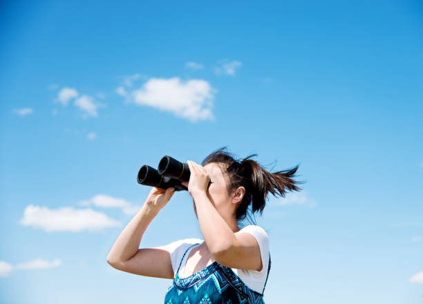 istock A woman looks at the sky with a binoculars 802473312