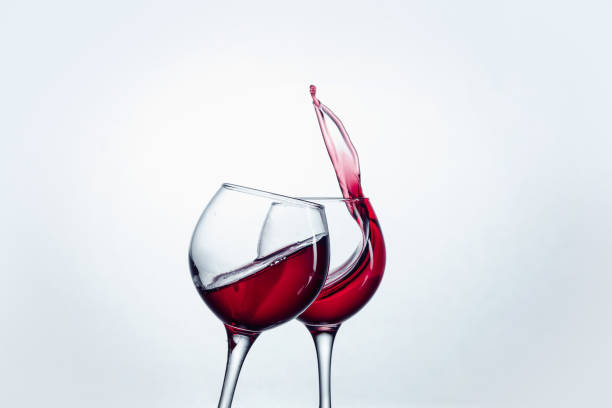 istock Two wine glasses in toasting gesture with big splashing 802473518