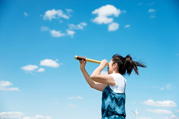 istock A woman looks at the sky with telescope 802473580