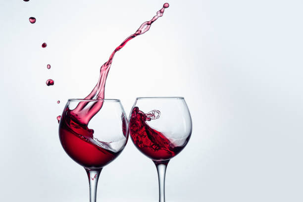 istock Two wine glasses in toasting gesture with big splashing 802473622