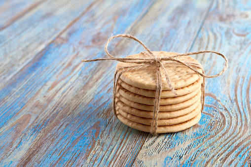Pile of corded cookies on blue wooden background