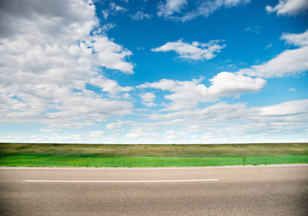 Road, grassland and sky with clouds Road, grassland and sky with clouds country road sky field cloudscape stock pictures, royalty-free photos & images