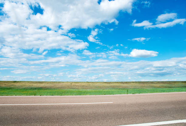 istock Road, grassland and sky with clouds 802493112