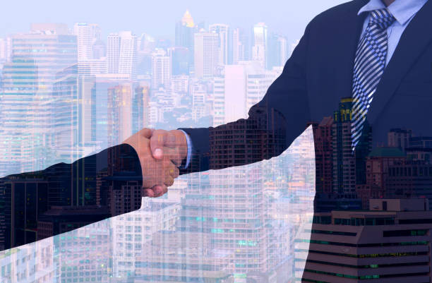 istock business handshake with city background, Double exposure style 802493858