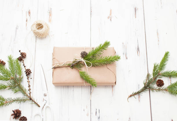 istock Wrapped gift in plain paper with a sprig of Holly and fir cones 802496192