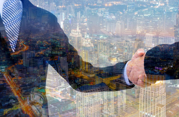 istock business handshake with city background, Double exposure style 802497346