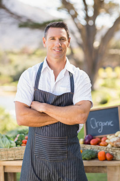 istock Smiling farmer standing with arms crossed 802502326