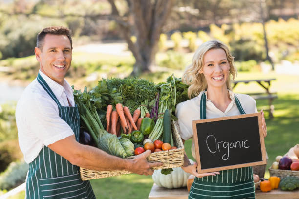 istock Smiling farmer couple holding a vegetable basket 802504860