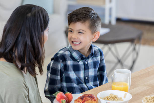 istock Adorable boy smiles at his mom during breakfast 802522432