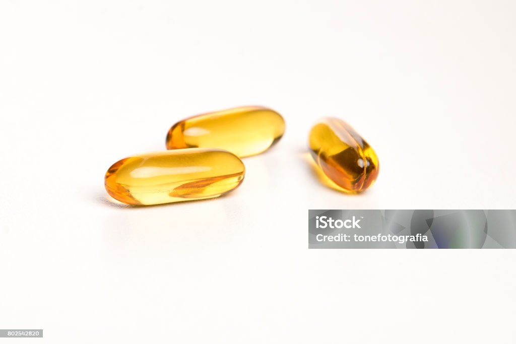 yellow pills on white background Omega-3 Stock Photo