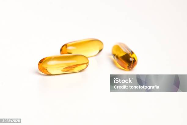 Yellow Pills On White Background Stock Photo - Download Image Now - Omega-3, Capsule - Medicine, Pill