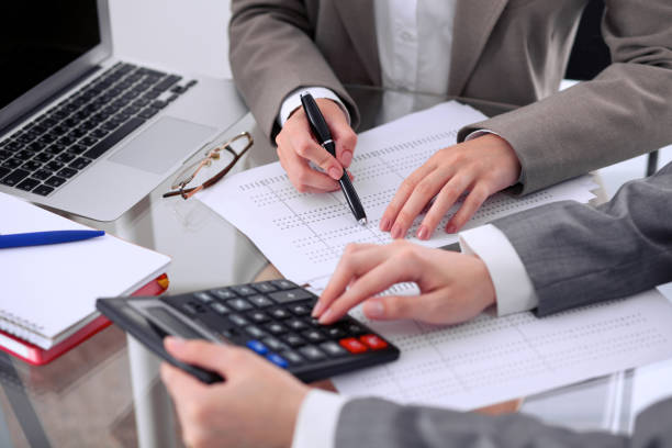 Two female accountants counting on calculator income for tax form completion hands closeup. Internal Revenue Service inspector checking financial document. Planning budget, audit concept. dos contadores mujer contando con ingresos de calculadora para impuestos forman closeup de las manos de terminación. inspector de servicio de impuestos interno comprobación de documento financiero. planificación presupuesto, concepto de auditoría