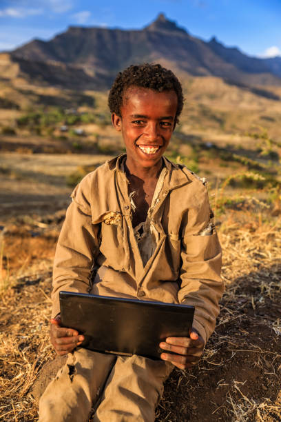 istock Young African boy is using digital tablet, East Africa 802545348