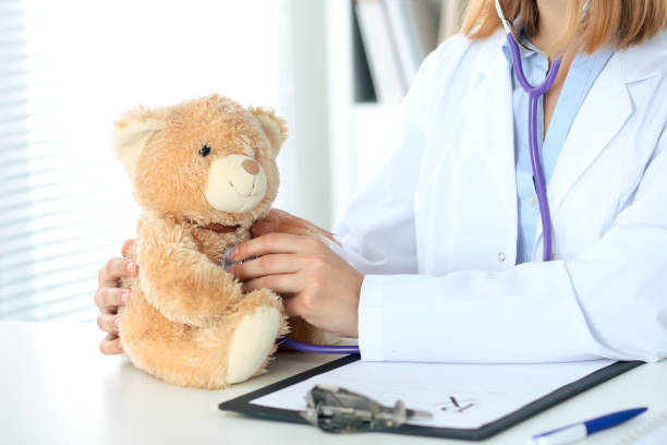 istock Female doctor examining a 
Teddy bear  patient by stethoscope. 802545602