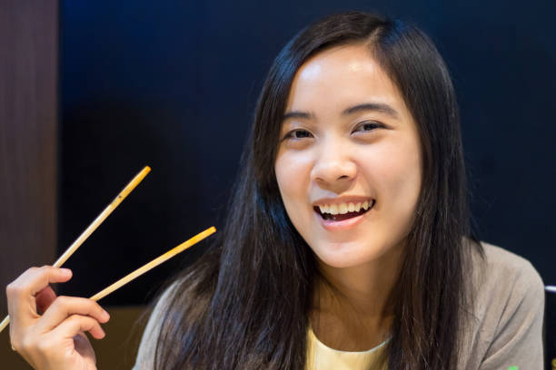 istock Asian woman eating with chopsticks 802546372