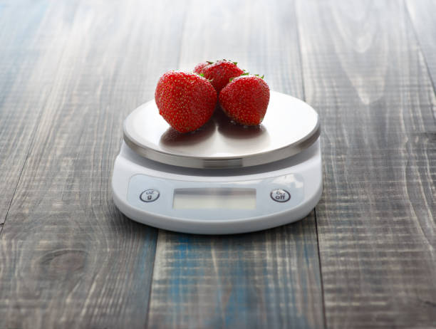 istock Weigh of strawberries on digital kitchen scales 802551154
