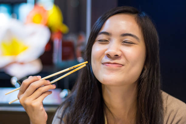 istock Asian woman eating with chopsticks 802551378