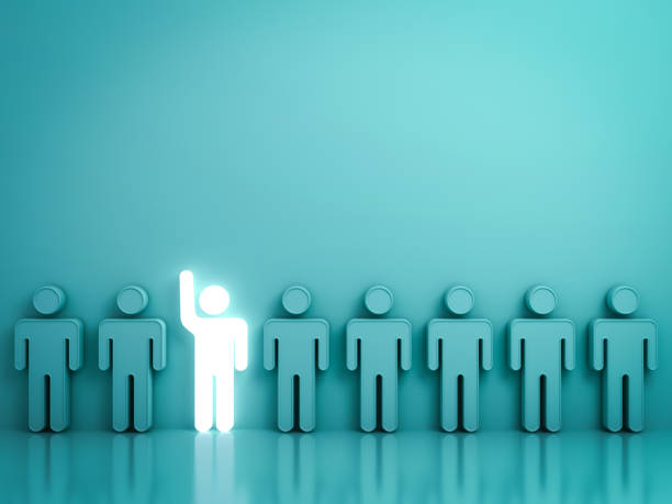 istock Stand out from the crowd and different concept , One glowing light man raising his hand among other people on green background with reflections and shadows . 3D rendering 802557394