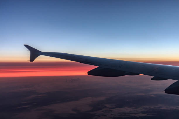 istock Wing of an airplane flying above the clouds 802558242