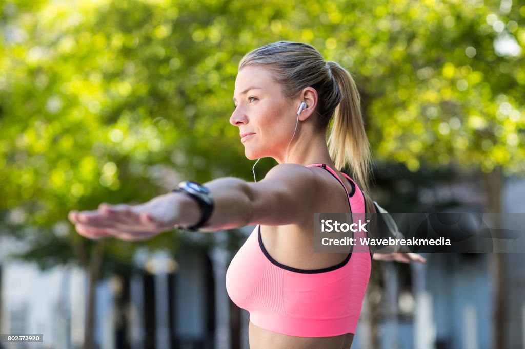 A beautiful athlete stretching her arms A beautiful athlete stretching her arms on a sunny day 20-29 Years Stock Photo