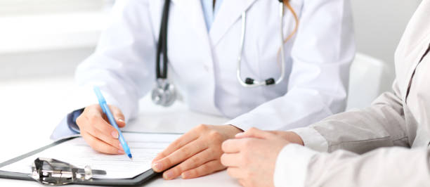 istock Doctor and  patient  sitting at the desk 802578850