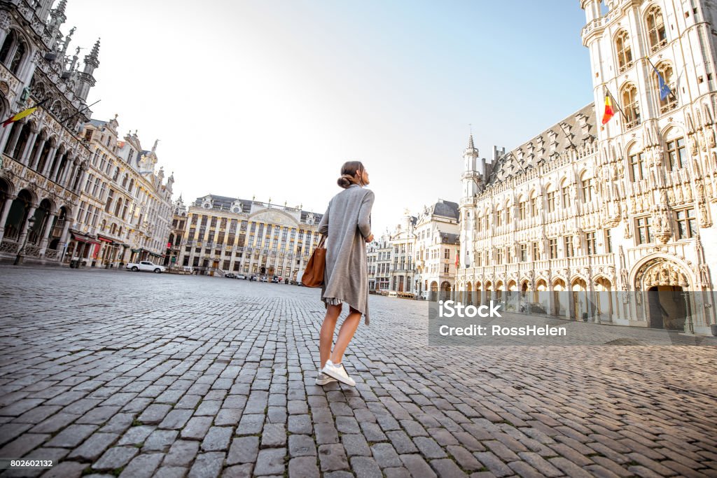 Woman traveling Brussels Young female tourist walking on the main square with city hall in the old town of Brussels in Belgium City of Brussels Stock Photo