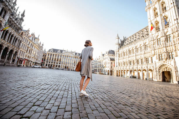 Woman traveling Brussels Young female tourist walking on the main square with city hall in the old town of Brussels in Belgium city of brussels stock pictures, royalty-free photos & images