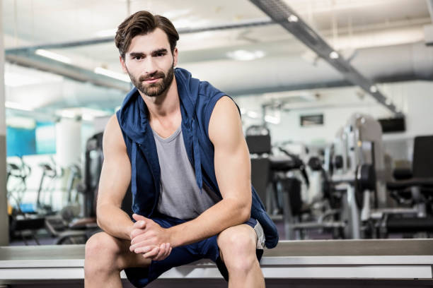 istock Handsome man sitting in the gym 802602694