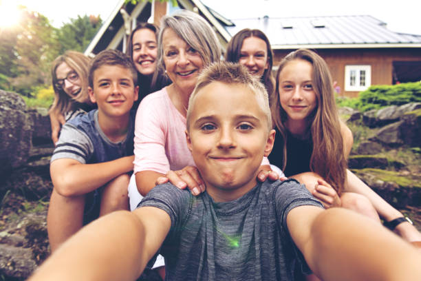 nieto tomando selfie de su abuela y primos - cousin fotografías e imágenes de stock