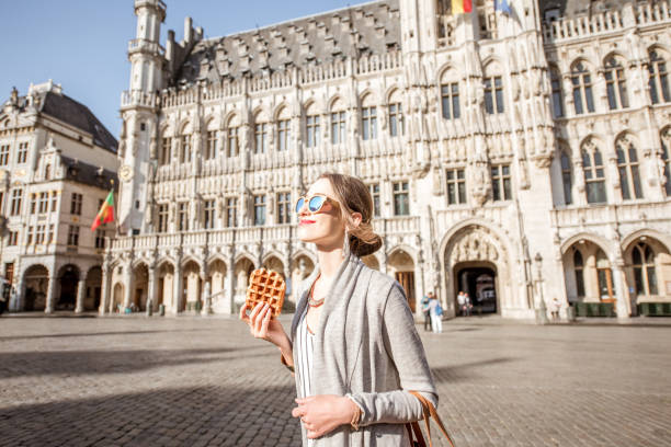 mujer con gofres belgas al aire libre - brussels waffle belgian waffle people fotografías e imágenes de stock