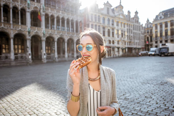 mujer con gofres belgas al aire libre - brussels waffle belgian waffle people fotografías e imágenes de stock