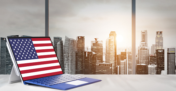 Independence Day on office laptop screen with panoramic sunset view of modern downtown skyscrapers at business district
