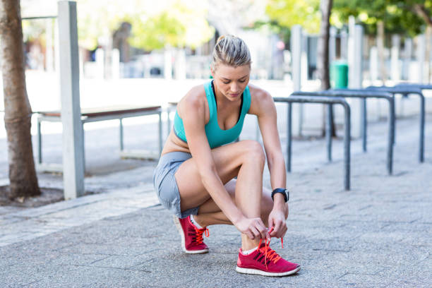 istock A beautiful woman tying her shoelaces 802618490